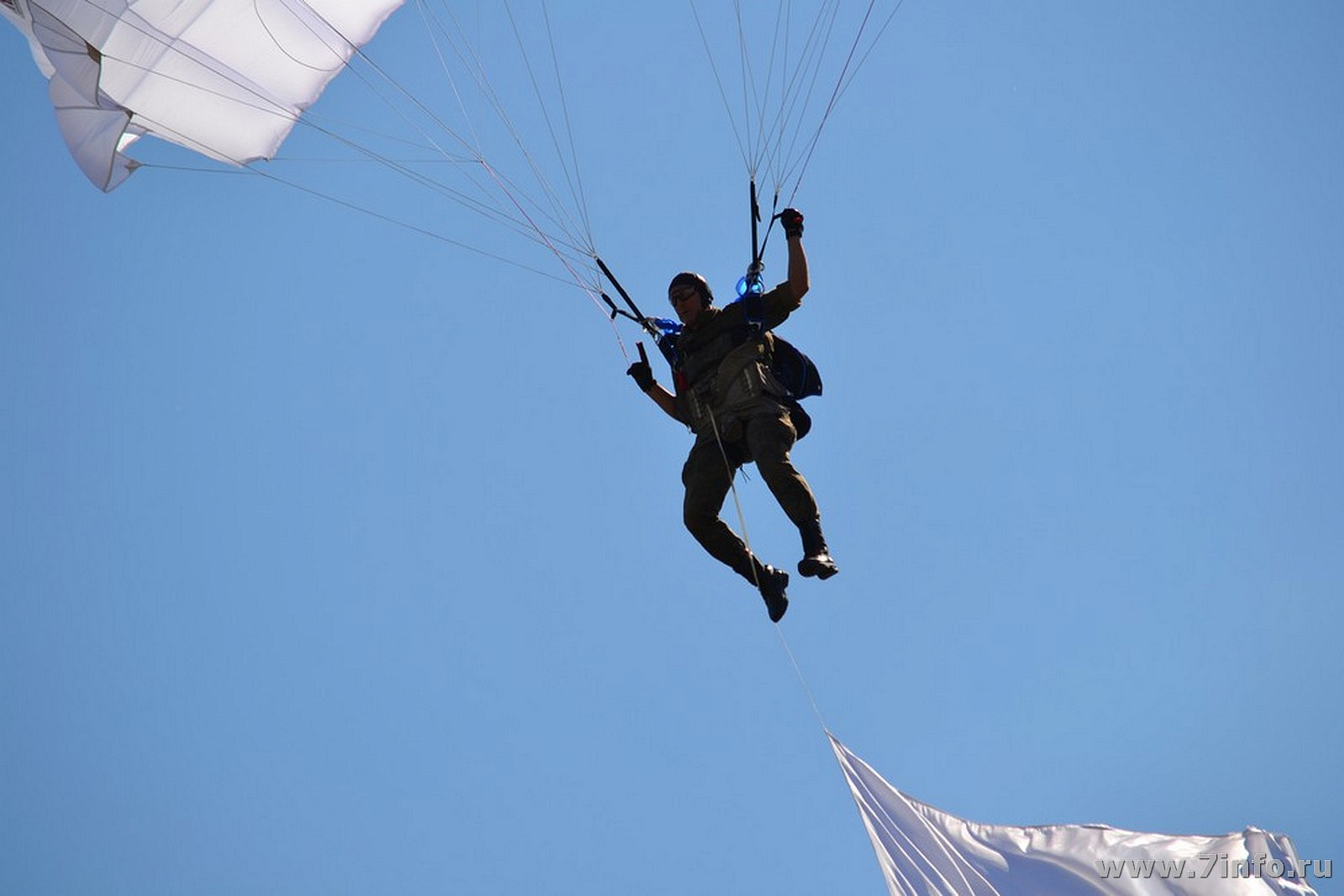 Спортсмен спускаясь на парашюте. Парашютист. Десантник с парашютом. Парашютист приземляется. Парашютист на дереве.